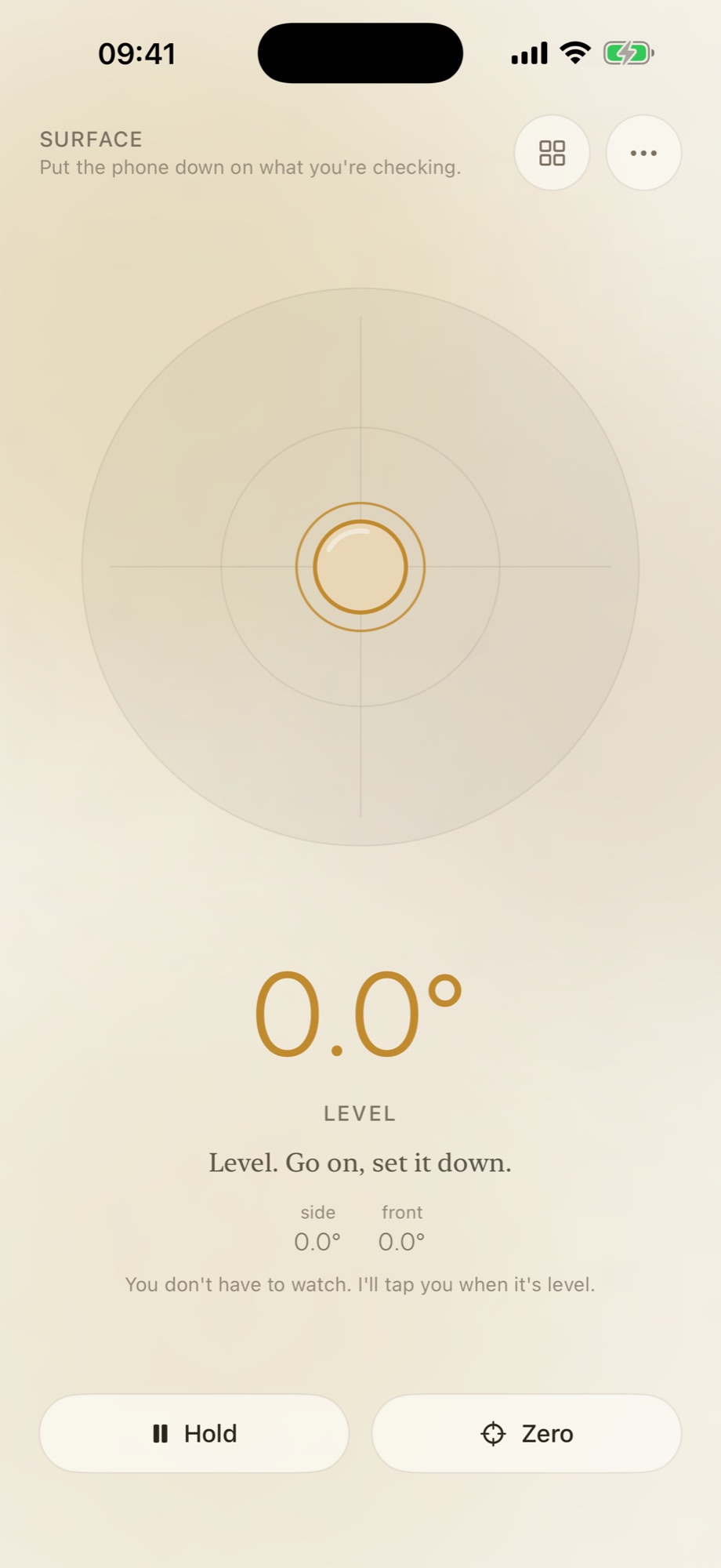 The measuring screen in Nana’s Level with the phone lying flat. A round bubble sits dead centre of the target, the reading underneath says 0.0 degrees, and Nana adds “Level. Go on, set it down.” Side and front both read 0.0 degrees, and a line at the bottom promises a tap when it is level. Hold and Zero buttons sit along the bottom.